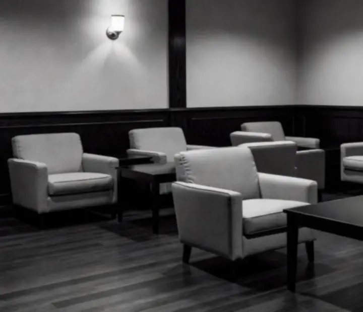 Mid-century card lounge with upholstered chairs and low lamplight.